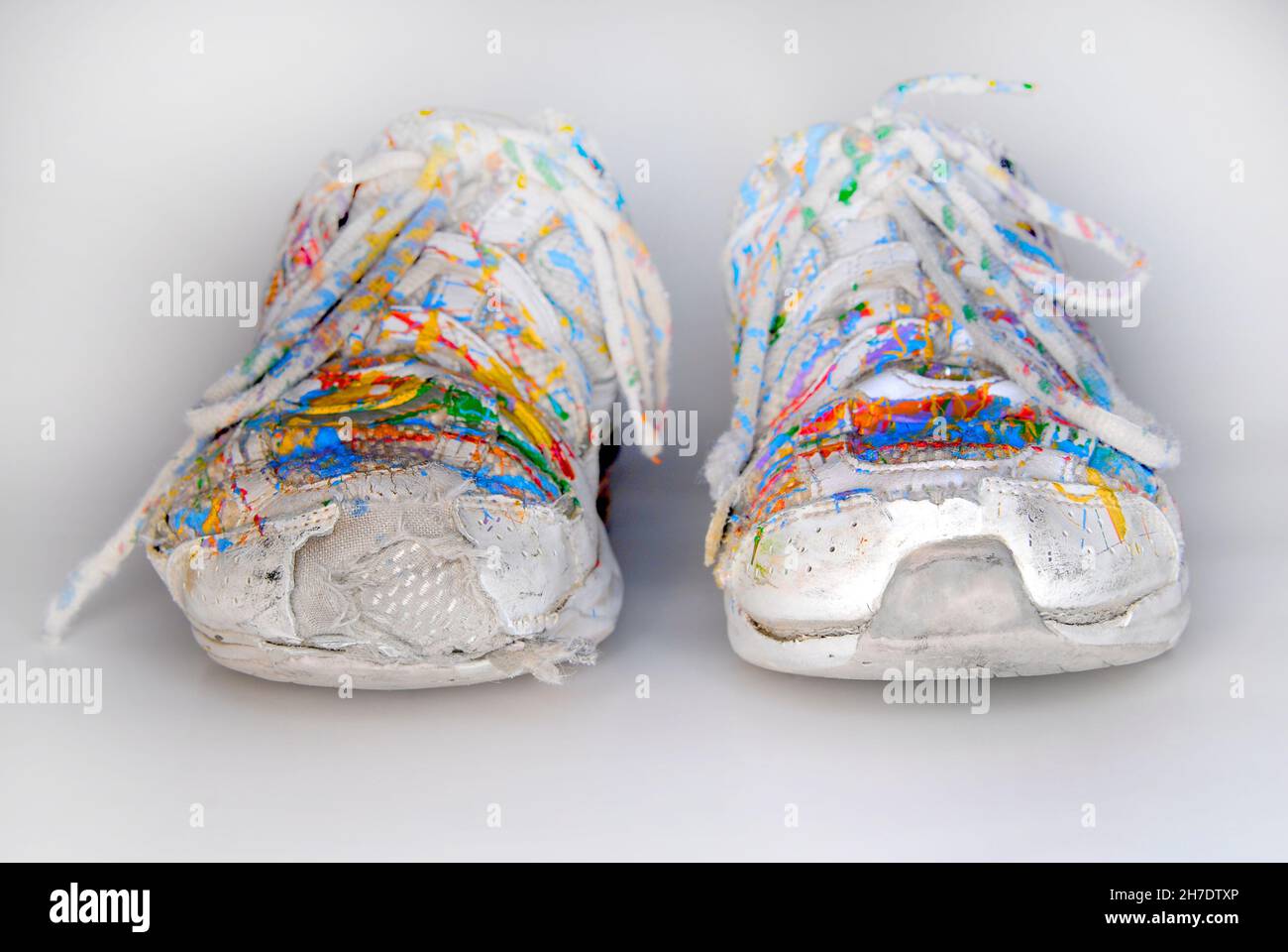 Old worn white shoes sneakers splattered in colorful paint Stock Photo -  Alamy