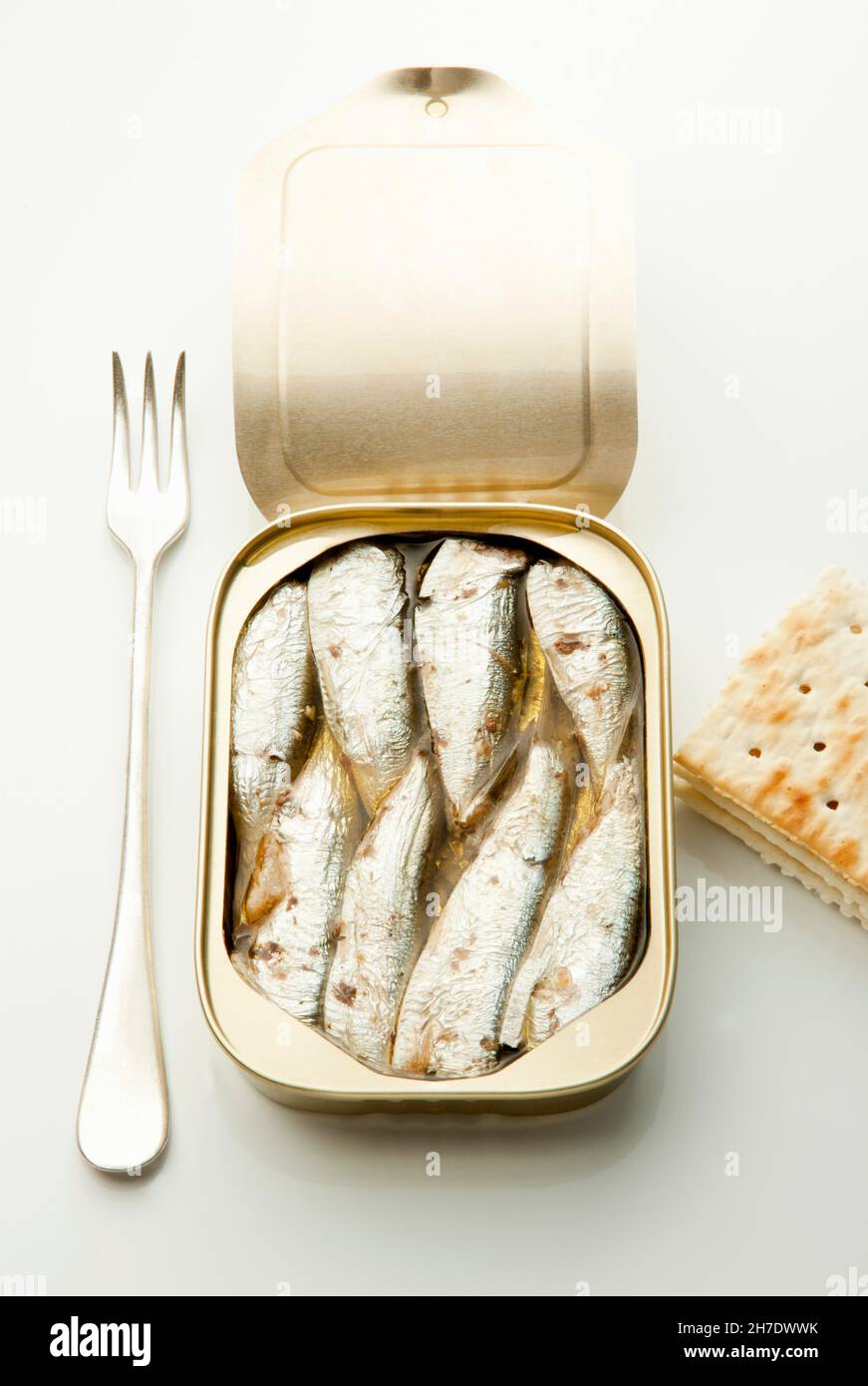 An open tin of sardines with a fork and crackers Stock Photo Alamy