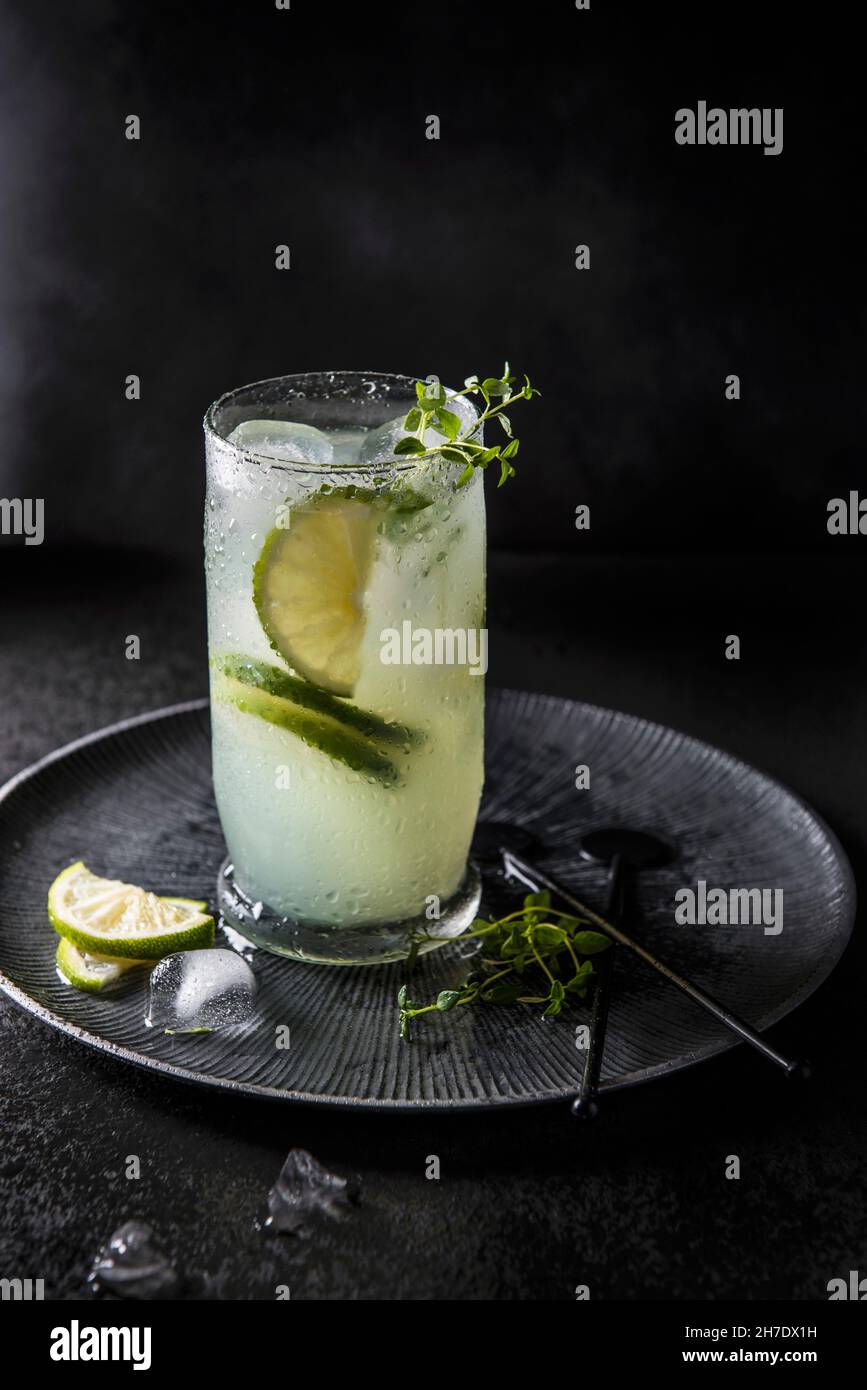 A cocktail made with bitter lemon, lime and gin on ice, garnished with thyme Stock Photo Alamy