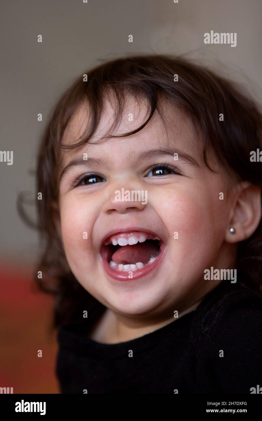 portrait of cute brunette baby giggling with desire Stock Photo