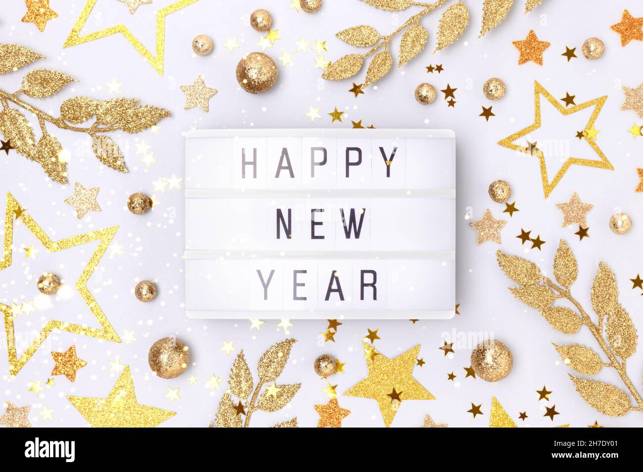Happy New Year. Lightbox and golden decorations on a blue background. Stock Photo