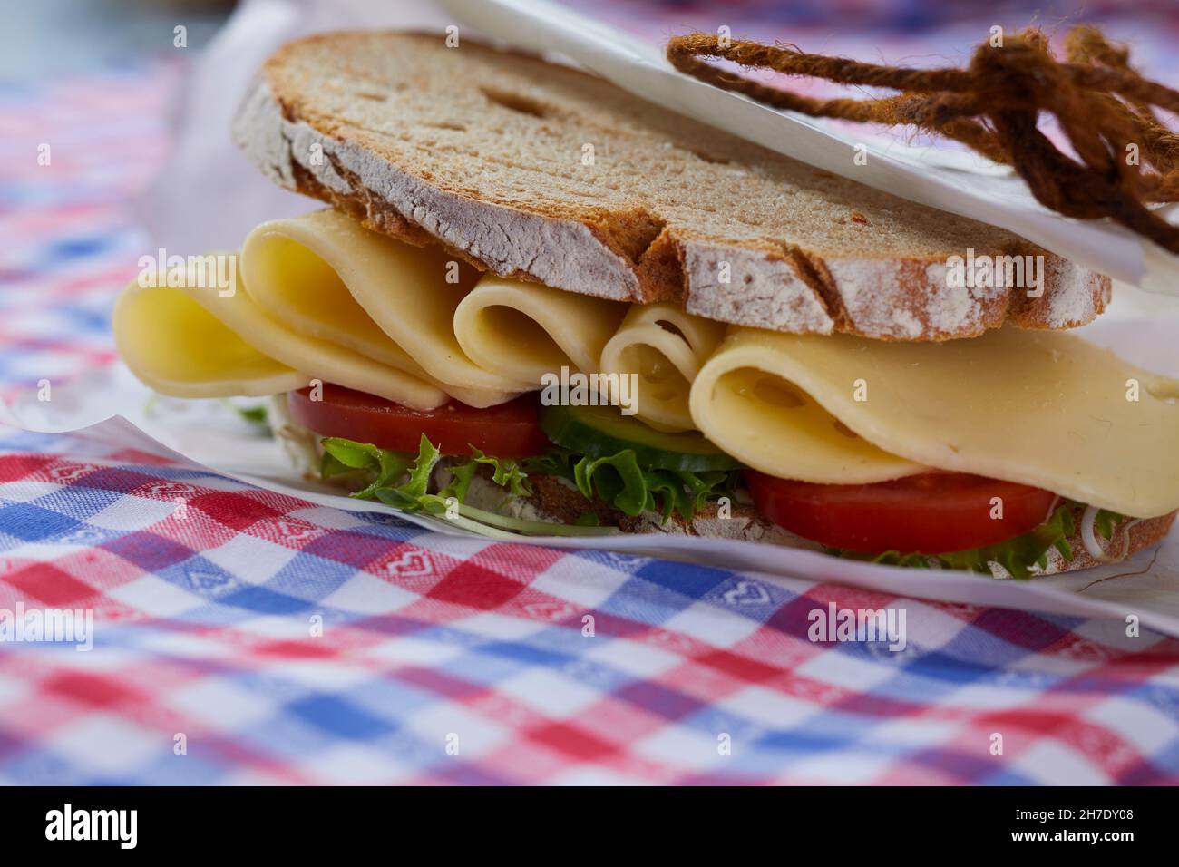 A sandwich made with crusty bread, cheese, tomatoes and salad Stock Photo