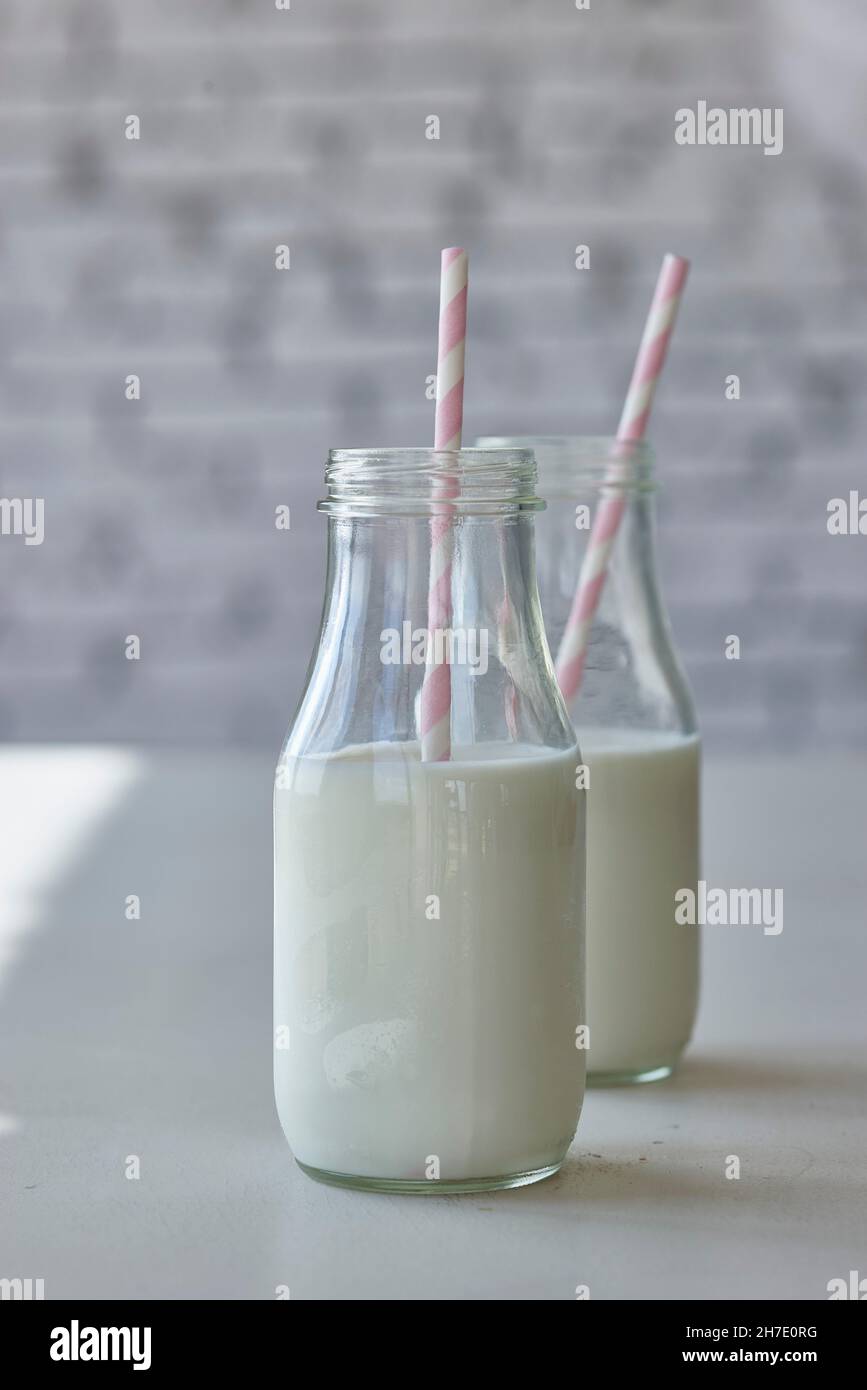 Bottles of milk with pink straws Stock Photo Alamy