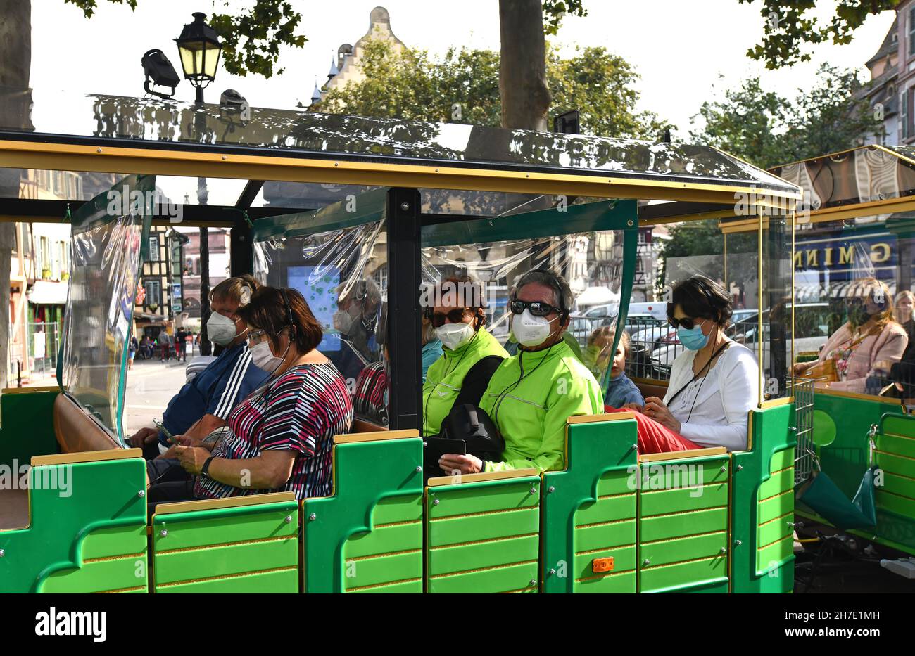 Tourists wearing Covid 19 pandemic face masks on sight seeing train in Colmar in Alsace region of France Stock Photo