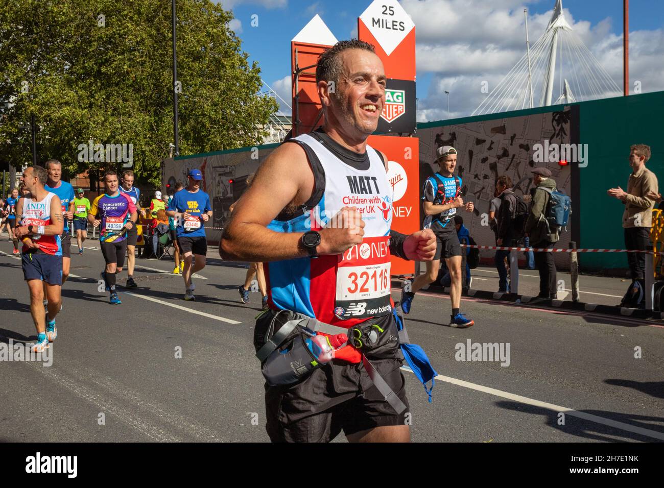 Smiling man running, Virgin Money London Marathon 2021 at the 25 mile point, Victoria Embankment. Stock Photo