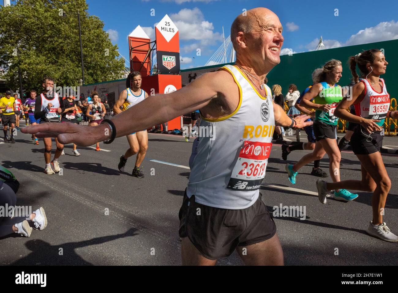 Man running with arms held out, Virgin Money London Marathon 2021 at the 25 mile point, Victoria Embankment. Stock Photo