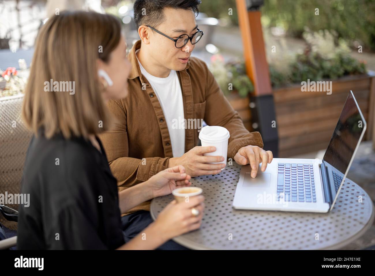 People talking and working with laptop in cafe Stock Photo