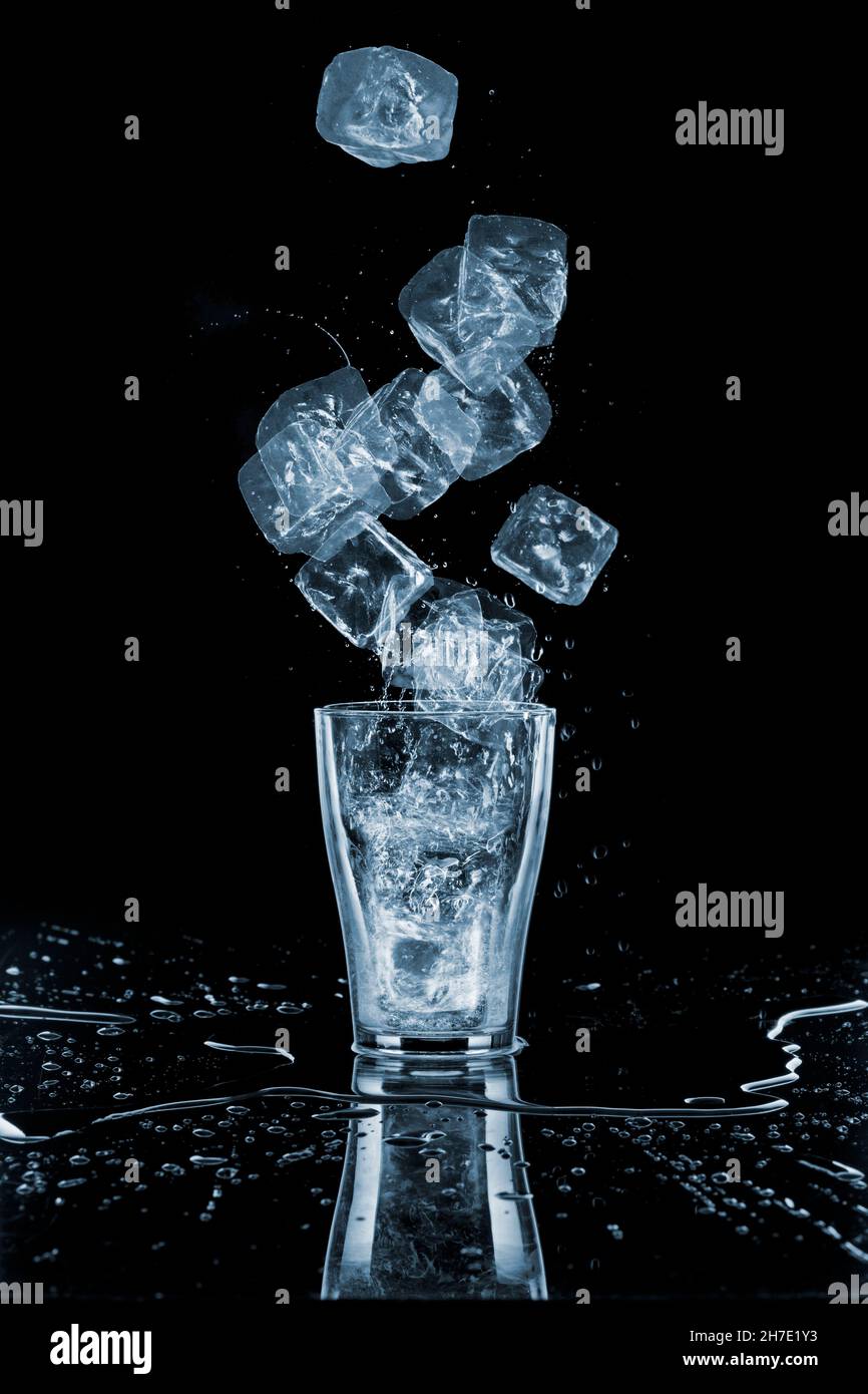 Glass of water with ice cubes around, close-up Stock Photo - Alamy