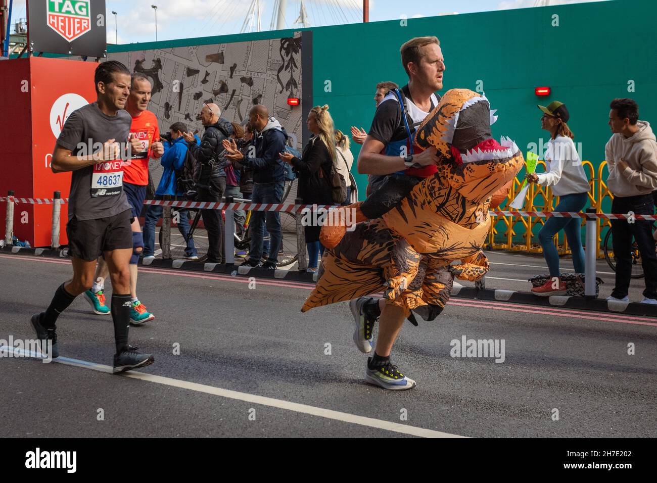 Man running dressed as a dinosaur, Virgin Money London Marathon 2021 at the 25 mile point, Victoria Embankment. Stock Photo
