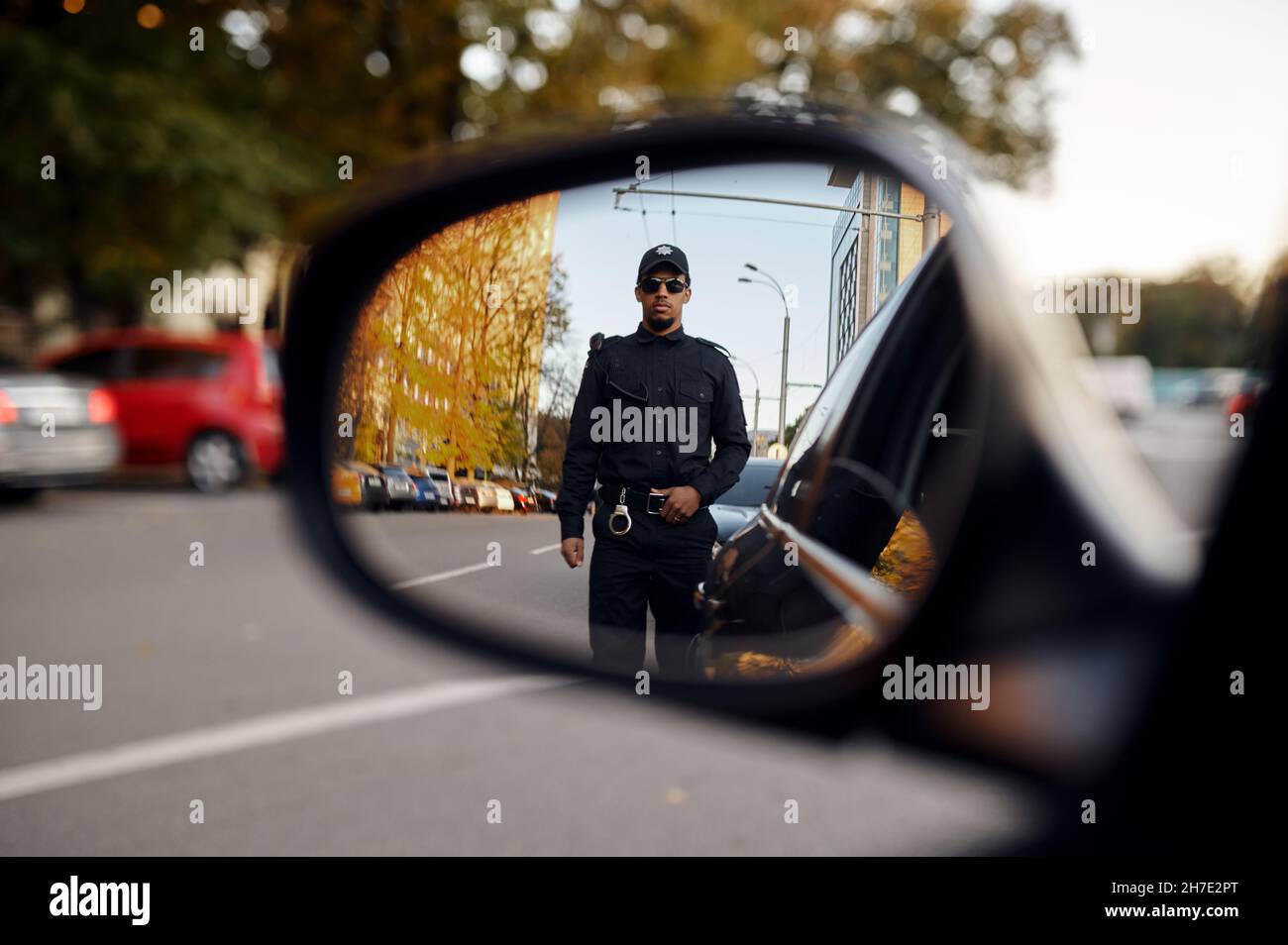 Police officer, view through car rear view mirror Stock Photo Alamy