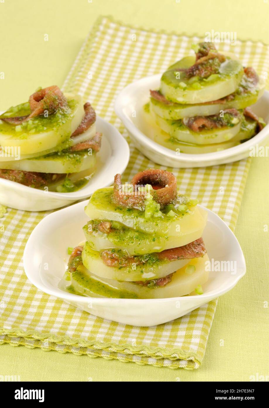 Potato mille feuilles with anchovies and herb sauce Stock Photo