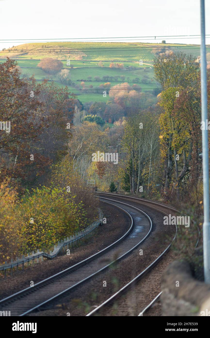 A Northern rail train passes through Calderdale beside the A58 main
