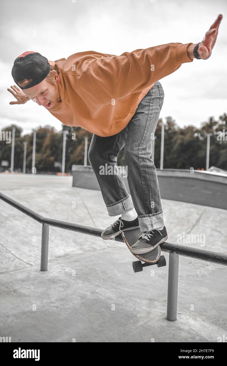 Guy on skateboard flying over railing in skatepark Stock Photo Alamy