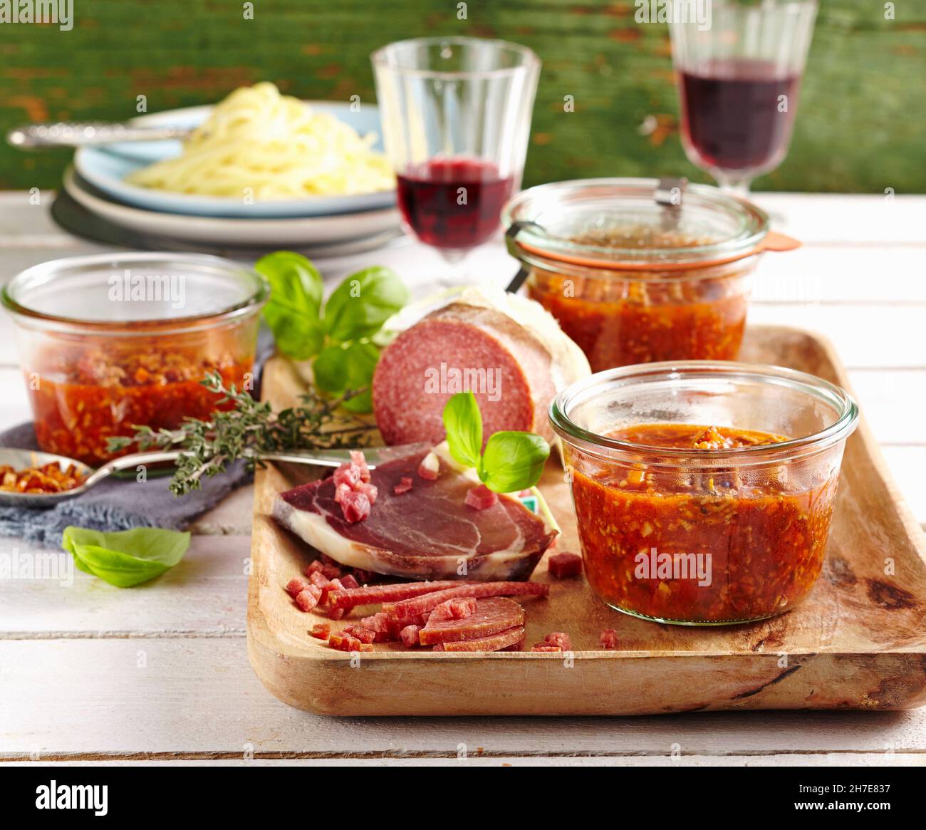 Bolognese sauce in preserving jars served with Parma ham and salami Stock Photo