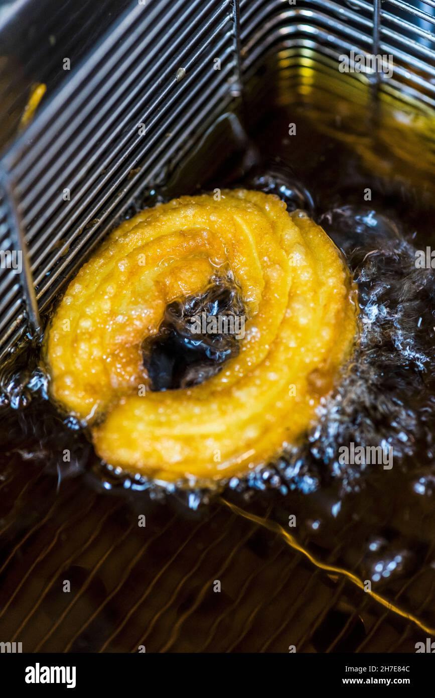 A churro in a deep fat fryer with oil Stock Photo Alamy