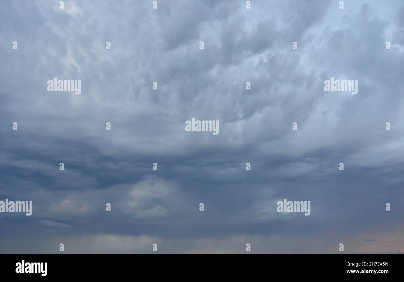 Heavy dark grey clouds on sky. Stock Photo