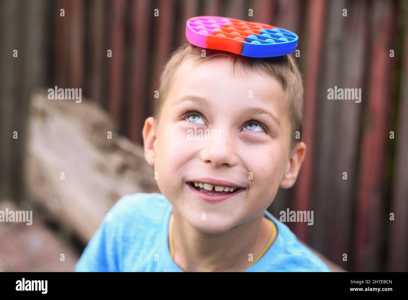 smiling boy with a toy pop it on his head Stock Photo