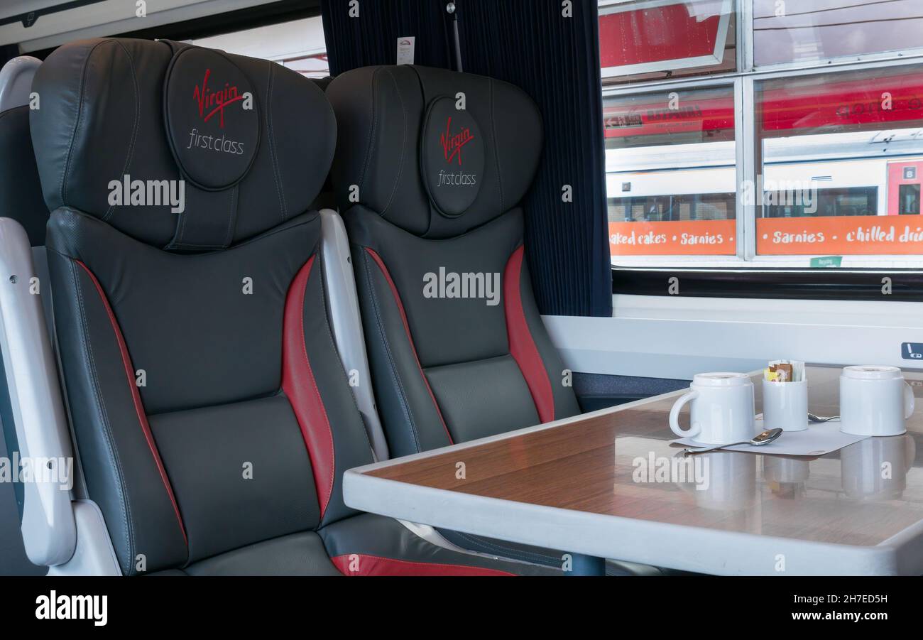 Virgin First Class logo brand on leather seats, Virgin mainline route, with table and coffee cups, UK Stock Photo