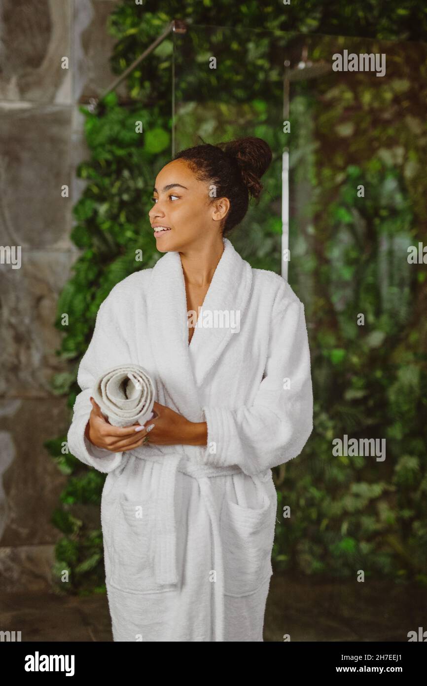 African American woman in white bathrobe resting in spa. Stock Photo