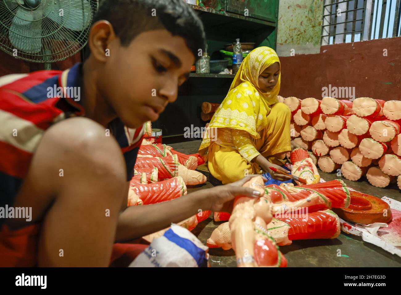 Dhaka, Bangladesh. 22nd Nov, 2021. Bangladeshi workers paint toys made
