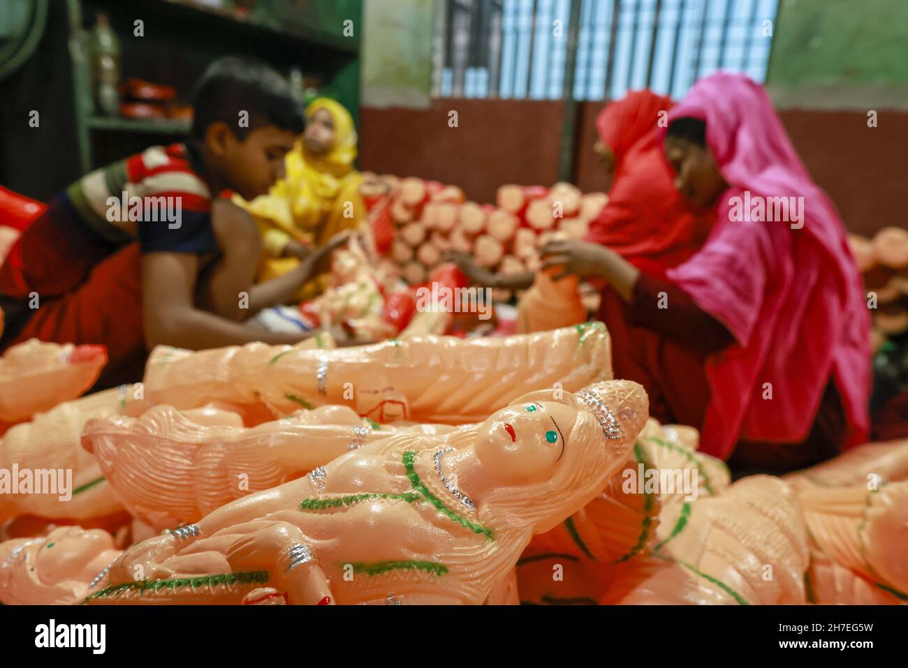 Dhaka, Bangladesh. 22nd Nov, 2021. Bangladeshi workers paint toys made