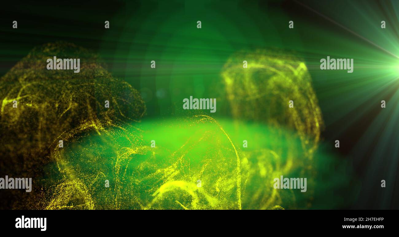 Image of yellow particles moving in green light on black background ...