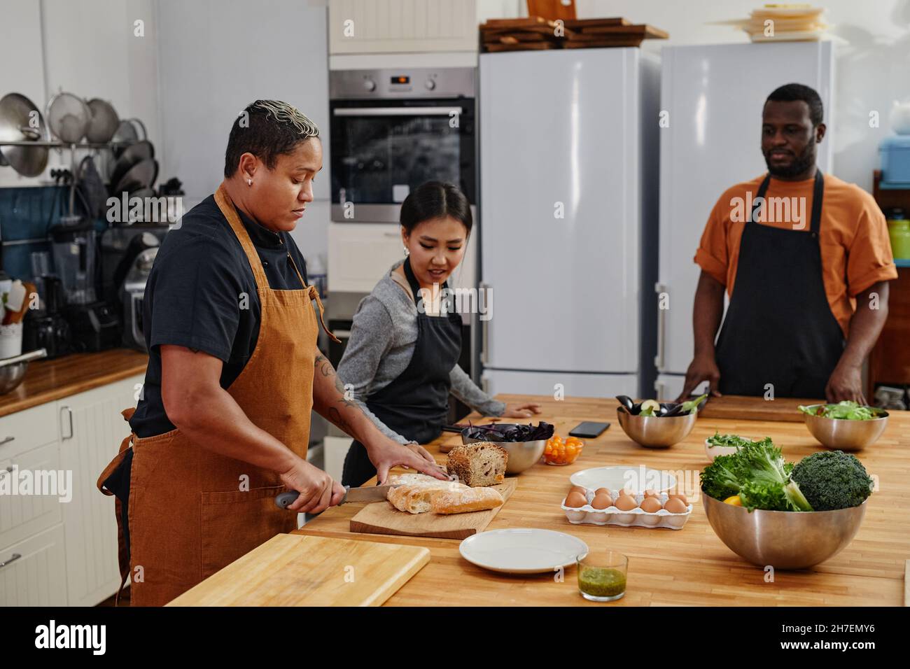 Side view at diverse group of people cutting vegetables together in ...