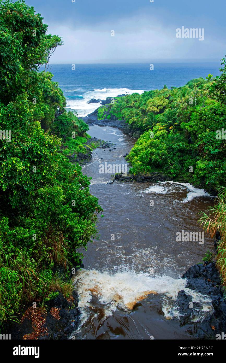 Palikea Stream running through volcanic rock into the ocean, Haleakala National Park, Maui, Hawaii Stock Photo