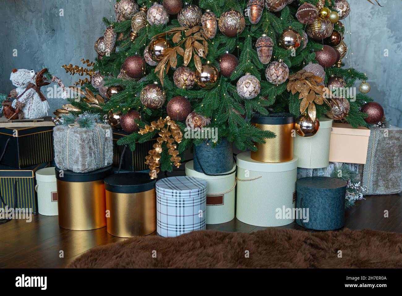 Christmas presents near tree with colorful balls. Stacked gift boxes for christmas. Stock Photo
