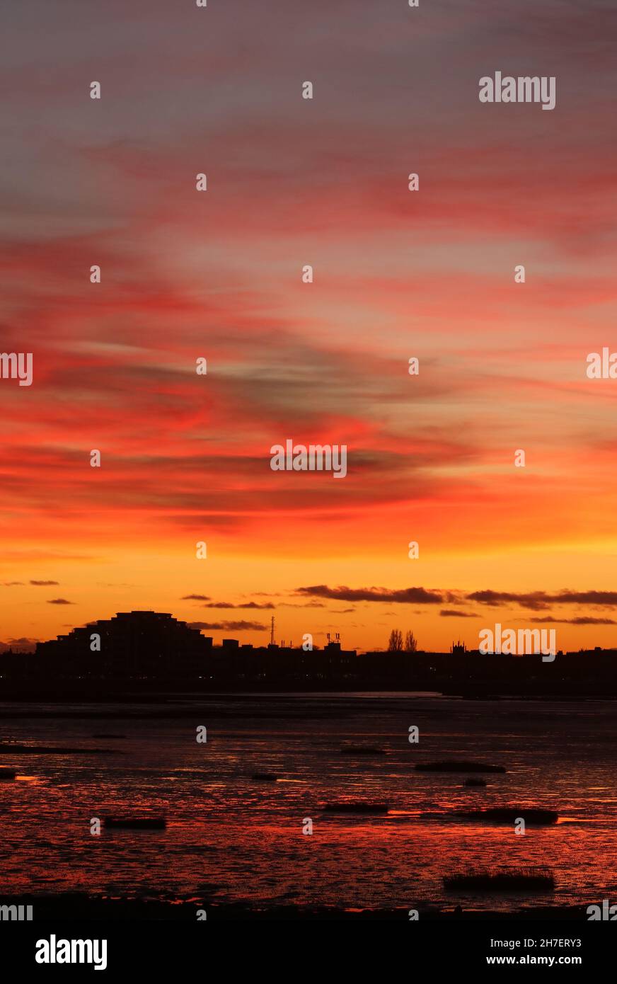 Silhouette of Morecambe promenade skyline at sunset with colorfulpink sky and reflected colors in seashore at Morecambe, Lancashire, November evening. Stock Photo