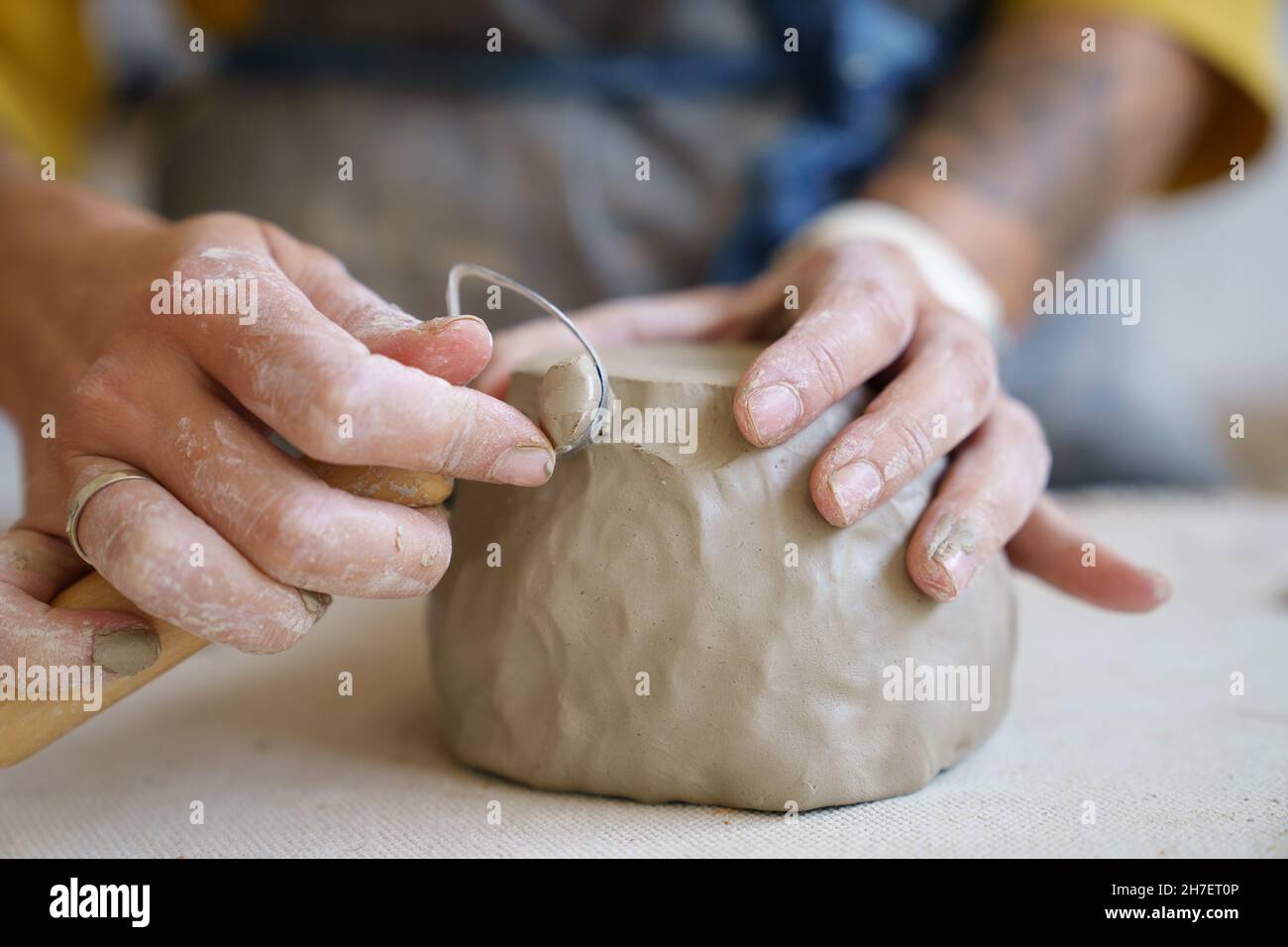 Ceramics creation process female artist shaping and sculpting clay pottery. Working table in