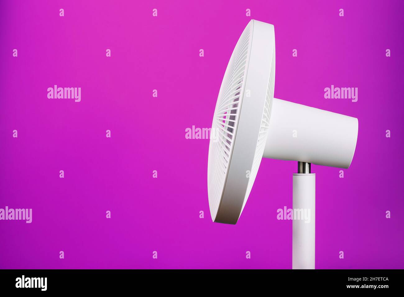 A hightech white electric fan with a modern design for cooling the room on a pink background
