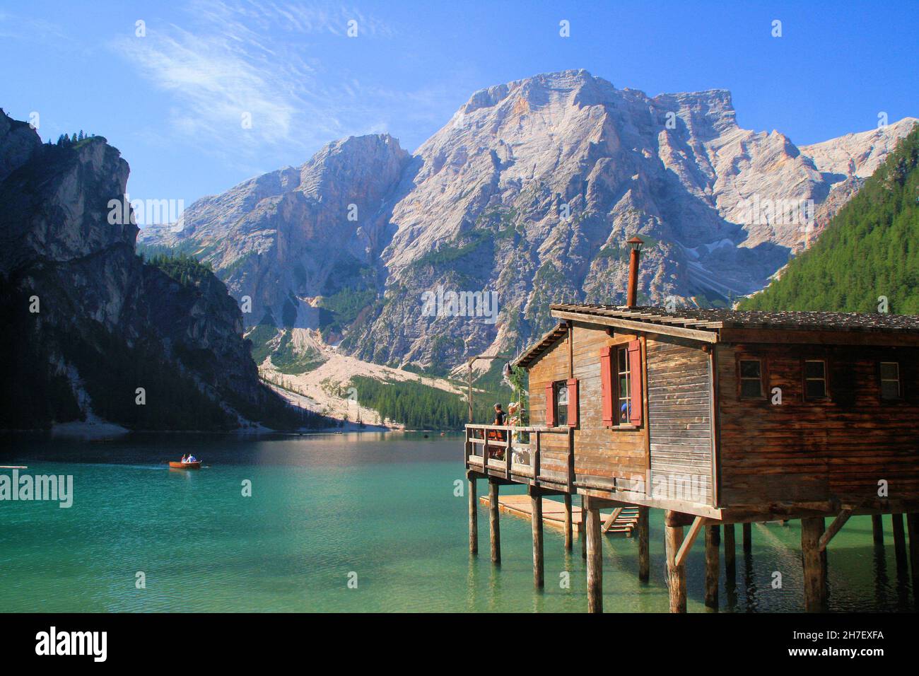 Landscape of Braies lake with surrounding mountains and wooden building (palafitte). Stock Photo