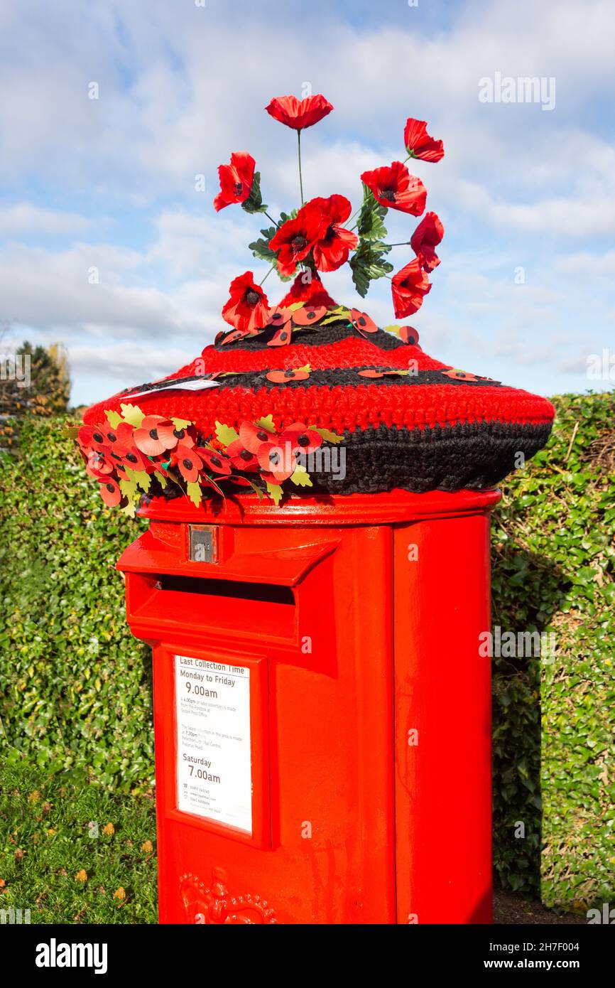 Crochet 'poppy rememberance day' postbox topper. Church Street, Stilton, Cambridgeshire, England, United Kingdom Stock Photo
