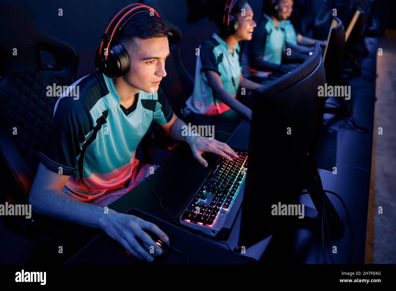 Determined man gaming with his friends in cyber club Stock Photo
