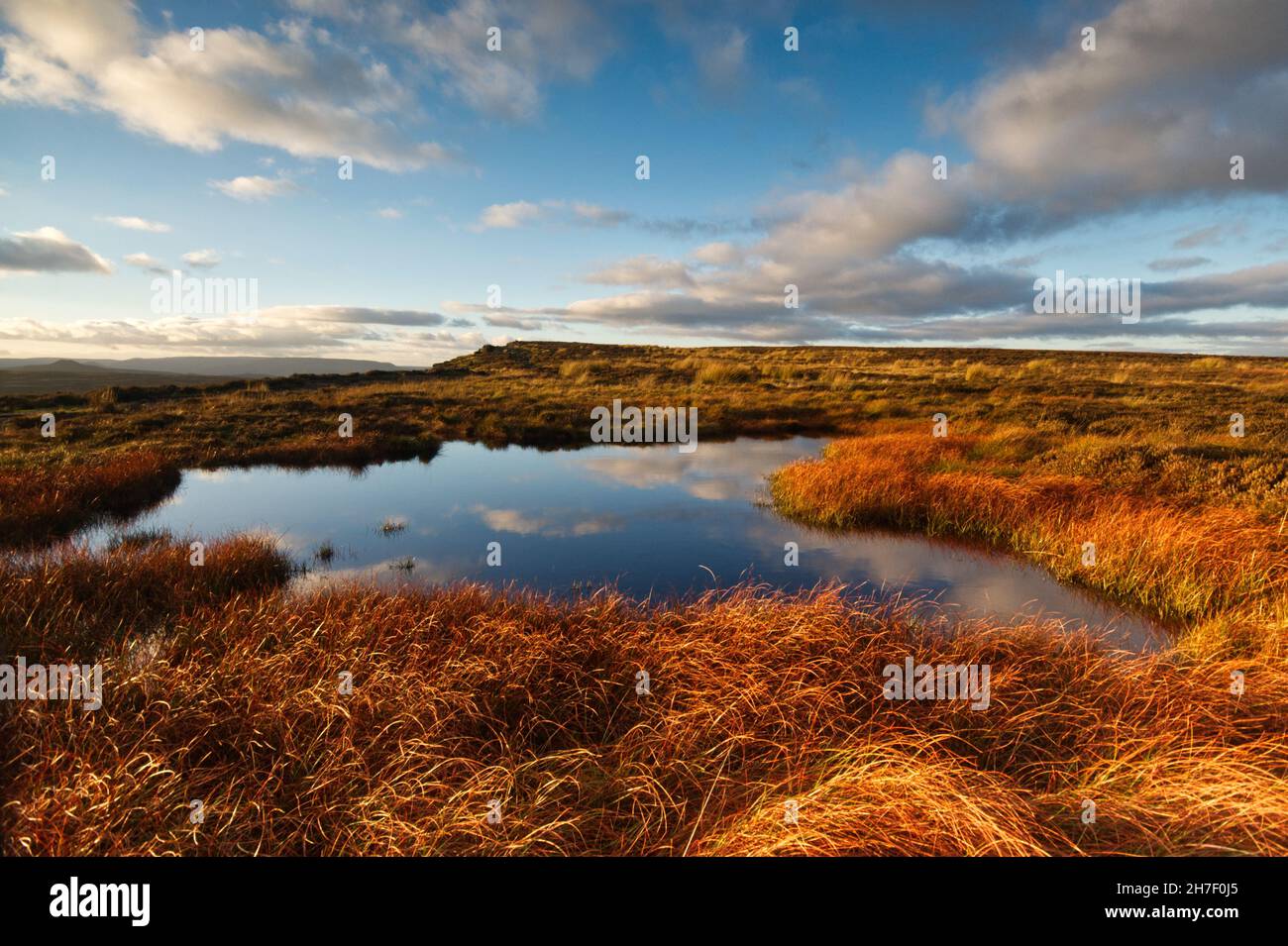 Sunset on Stanage Edge in the Peak District National Park. Reflections of the sky in standing water mirror the scene. Stock Photo