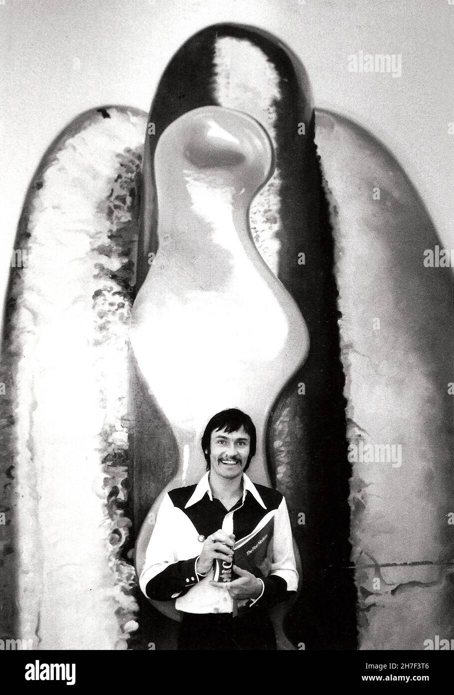 Paul Whitehead poses in front of a billboard with a hand-painted hot dog at the Foster and Kleiser billboard studio in Los Angeles, CA circa 1977 while organizing the Eyes And Ear Foundation art on billboards campaign. Stock Photo