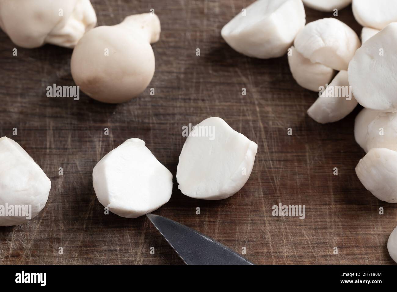 Cooking edible puffball mushrooms. Cutting peeled mushrooms on a cutting board, closeup. Stock Photo