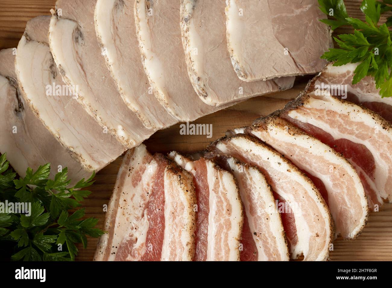 Sliced pork deli meats on wooden platter Stock Photo