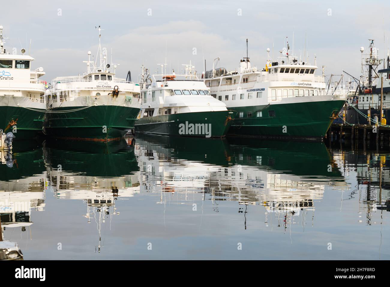 Seattle - November 21, 2021; Boats of the UnCruise Adventures company ties up for winter at Fishermens Terminal in Seattle.  The green and white ships Stock Photo