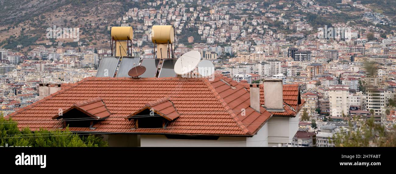 Barrels of water heated by solar panels installed on roof of house ...