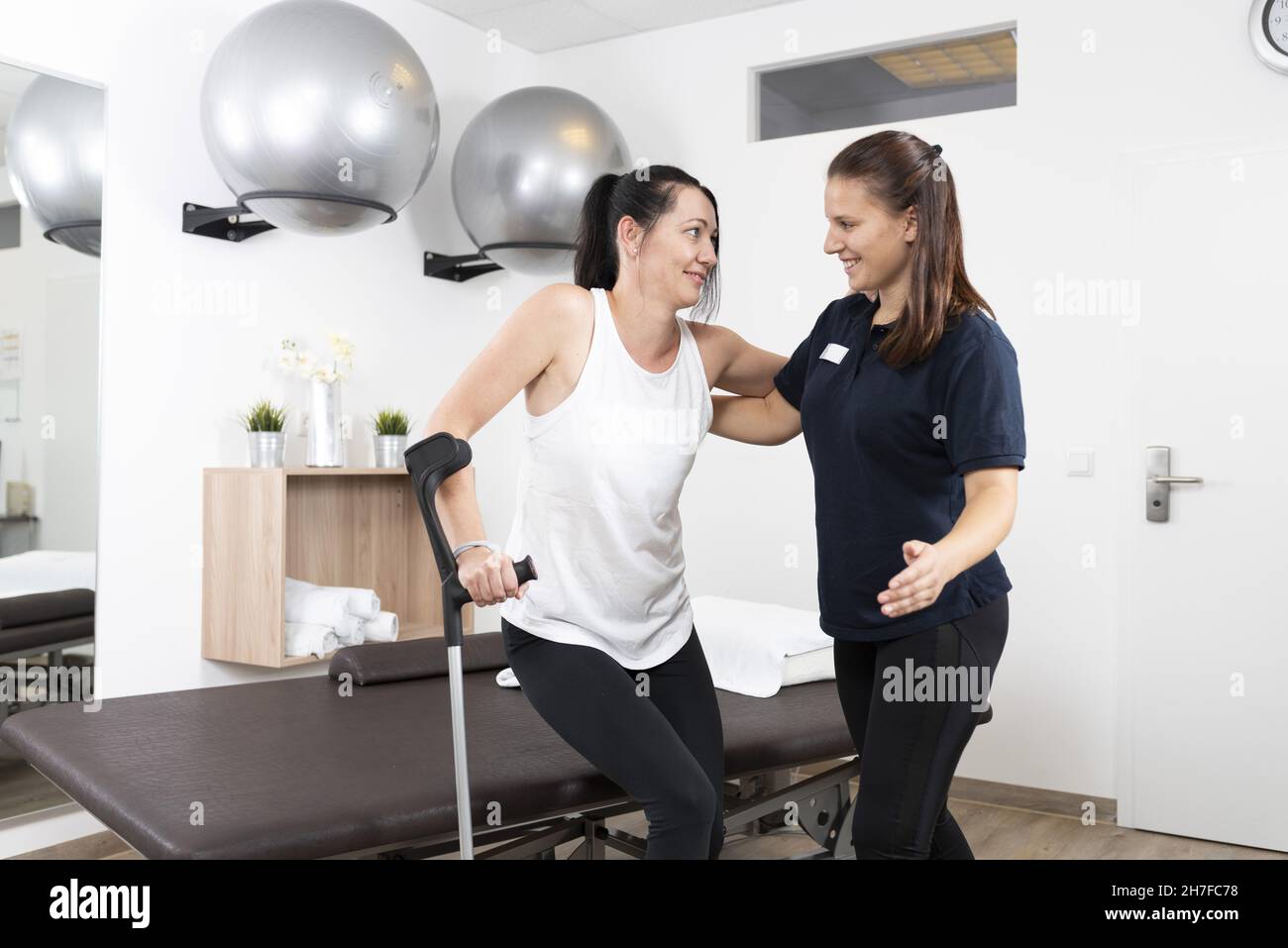 Doctor helping her patient on crutches Stock Photo Alamy