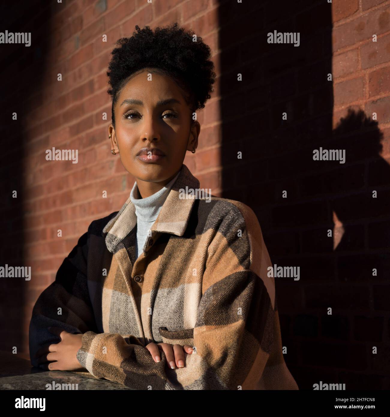 Portrait of a young woman in a brown and beige flannel shirt jacket