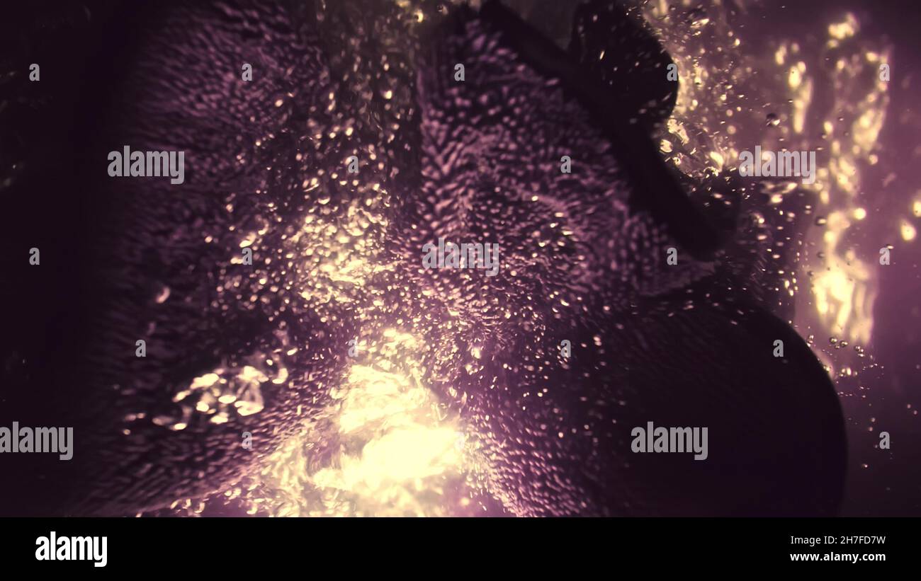 A professional dry microfiber rag for washing a car is dipped in water