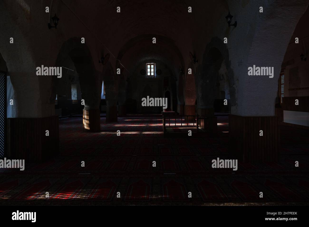 Inside the ancient mosque of Karamanoglu brahim Bey Mosque (Camii) in urgup. Sun lights coming from their windows on the carpets for muslim prayers. Stock Photo