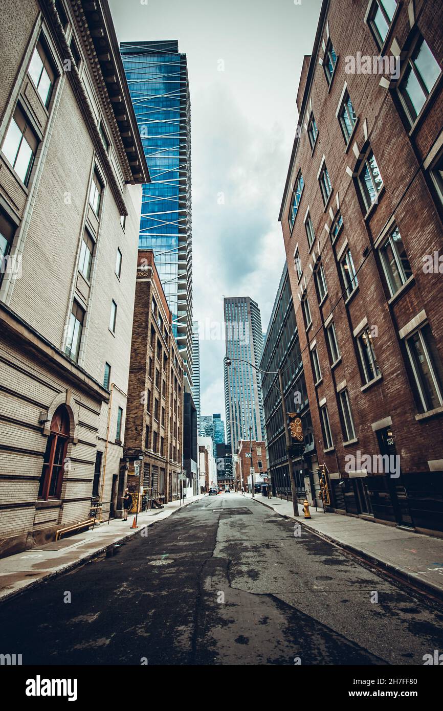 Vertical shot of a road surrounded by modern buildings under a cloudy ...