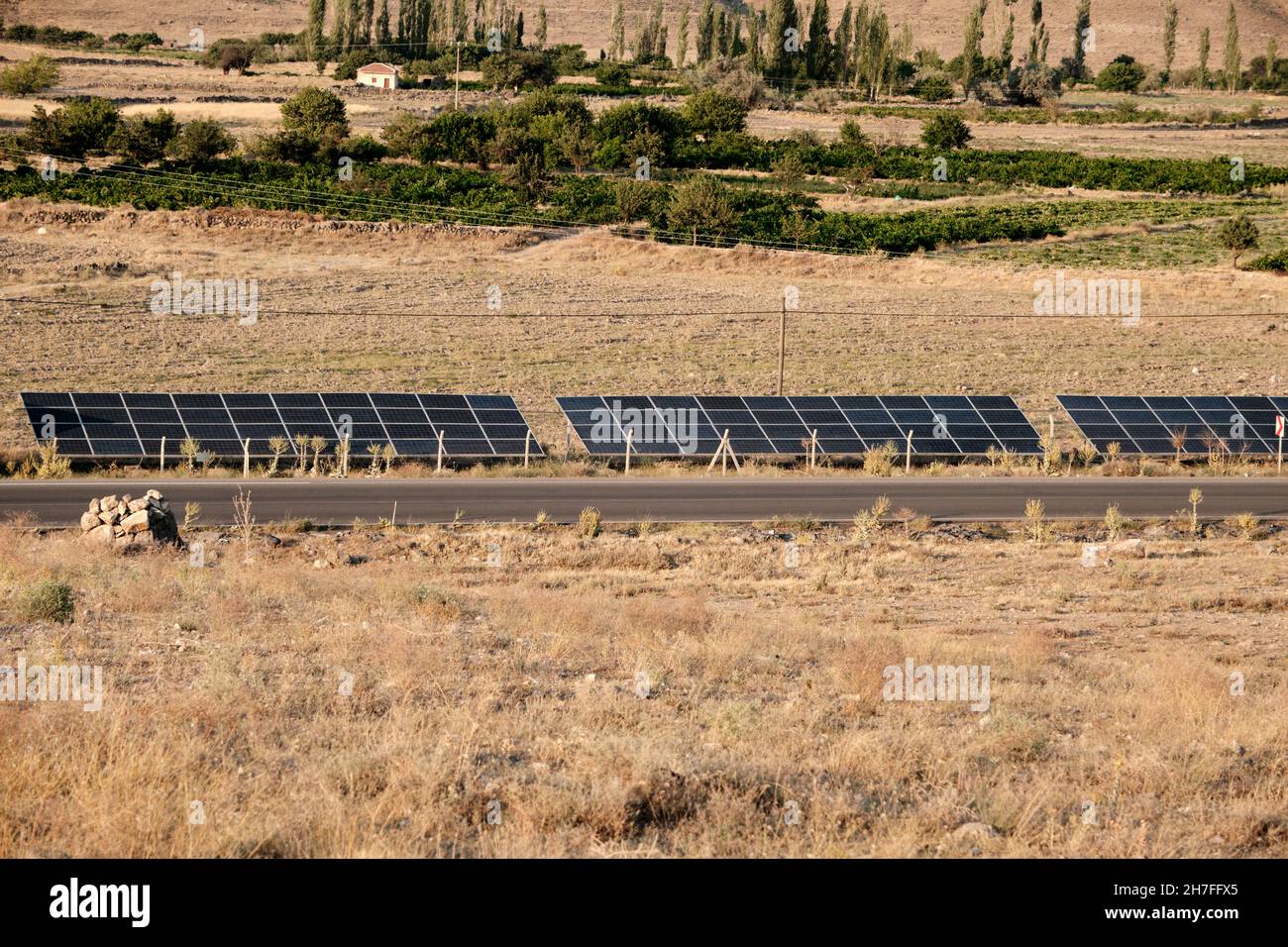 Solar energy panels near the highway covered with yellow grass in Aksaray Turkey Stock Photo