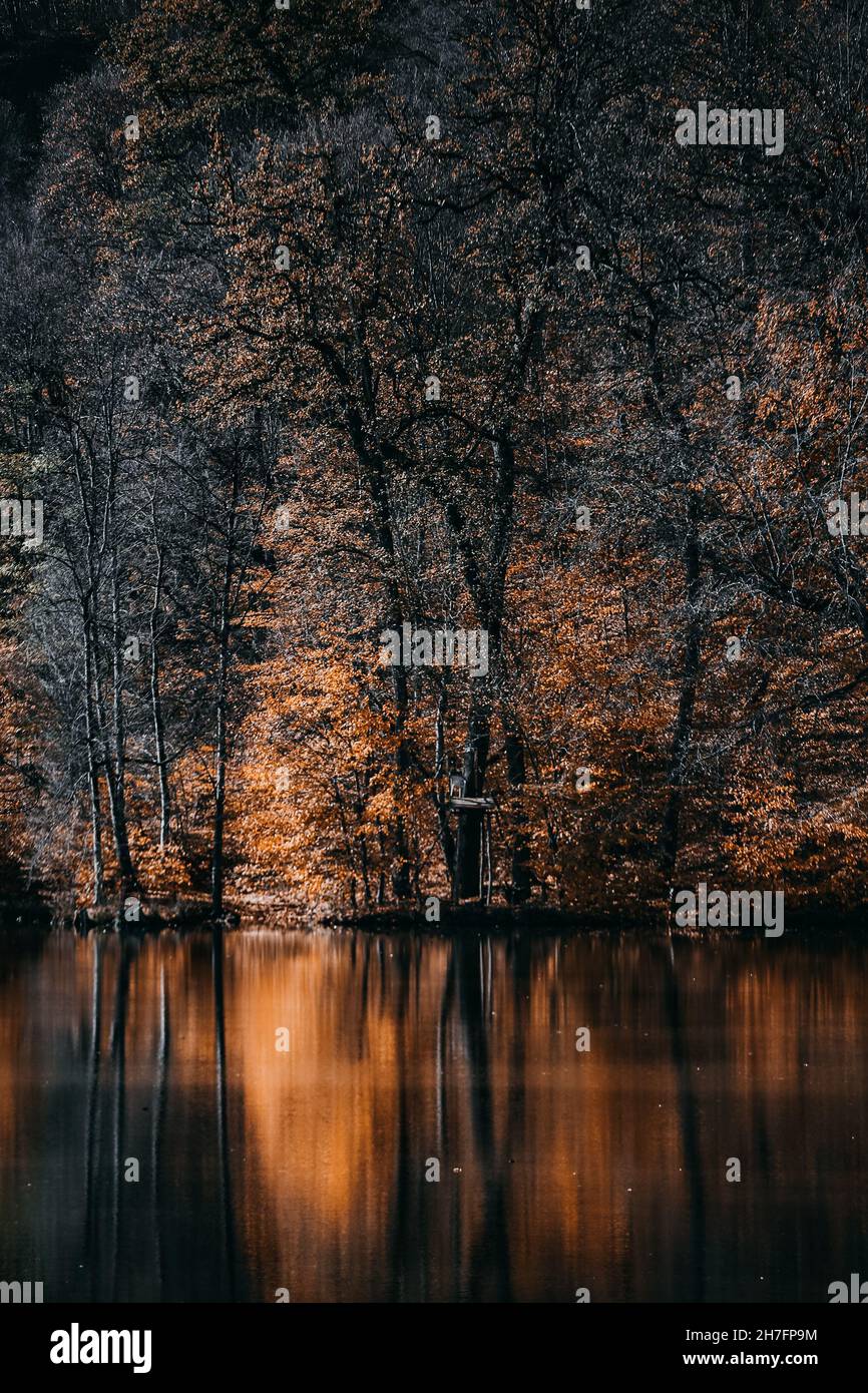 Vertical shot of Lake Parz with long exposure surrounded by trees in autumn in Dilijan, Armenia Stock Photo