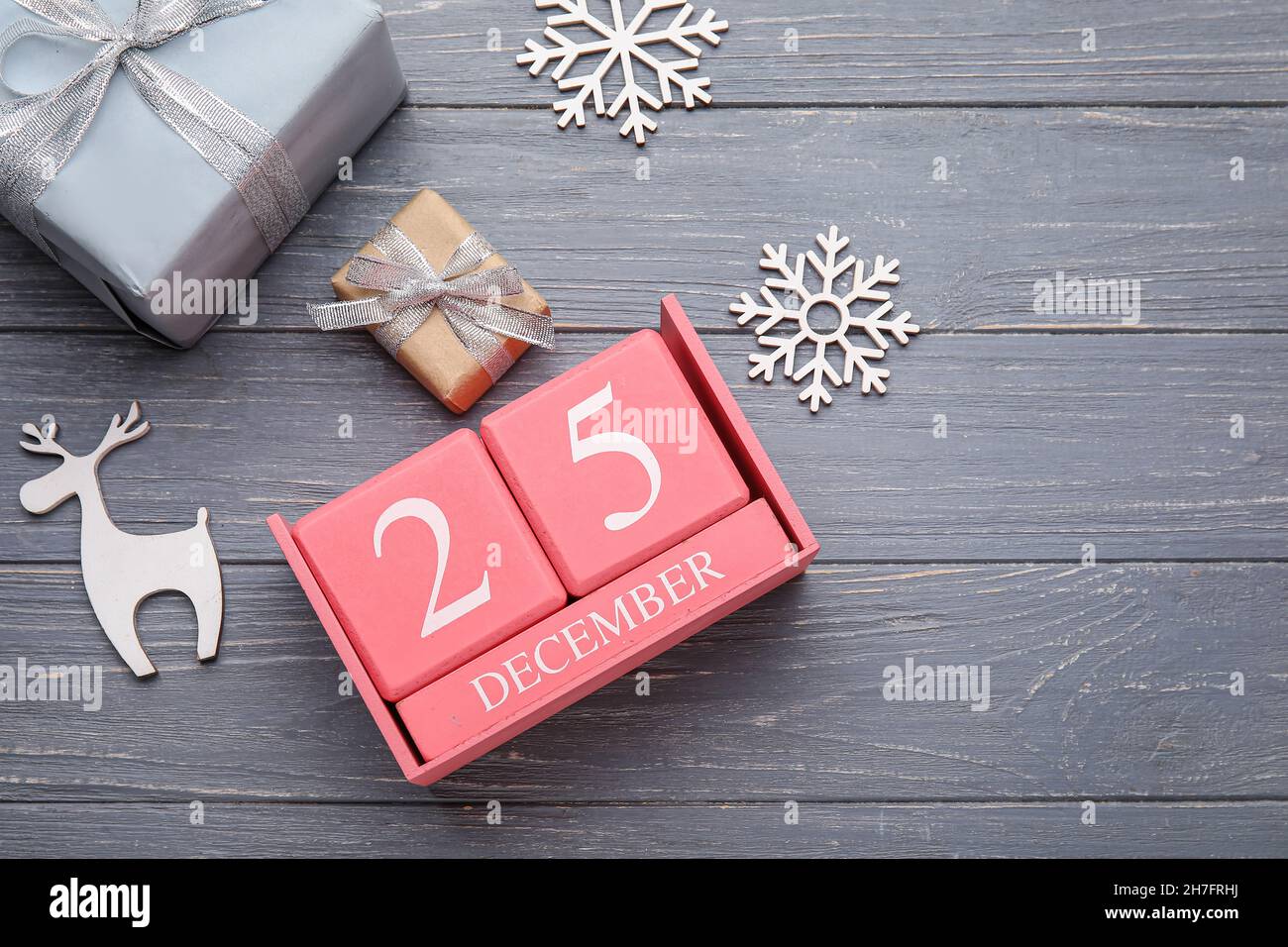 Calendar with date of Christmas, gift boxes and decorations on grey