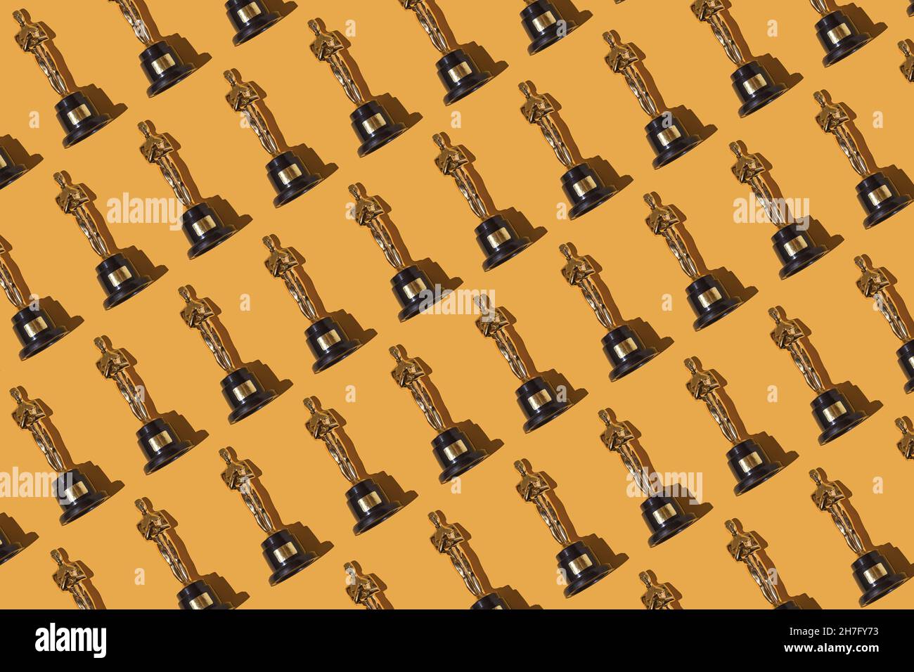 Oscar awards trophy pattern on yellow background. Award, film industry, Hollywood and winner concept. Stock Photo